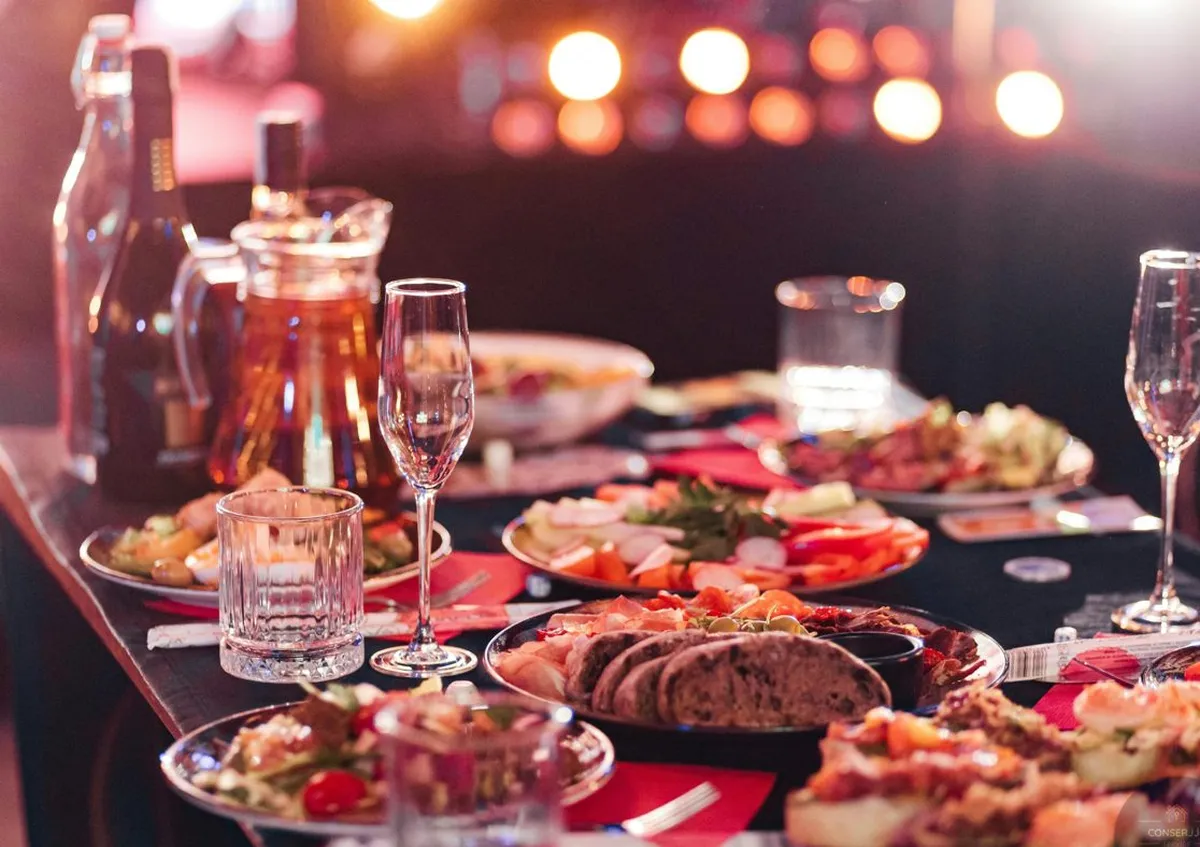 Mesa de cena gourmet con platos para compartir y copas de vino